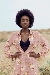 Woman in floral dress standing on yellow grass field
