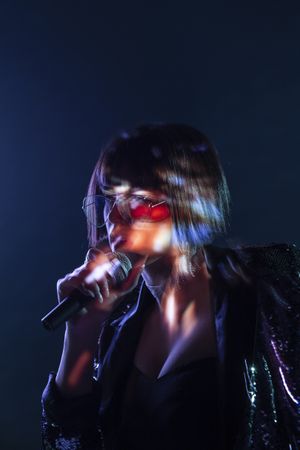 Stylish woman singing on stage