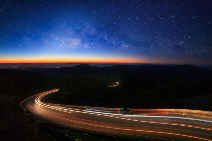 Milky way galaxy with stars and space dust in the universe and lighting on the road before morning at Doi inthanon Chiang mai, Thailand