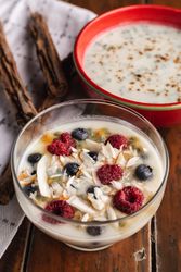 Yogurt in glass bowl with berries and cinnamon sticks