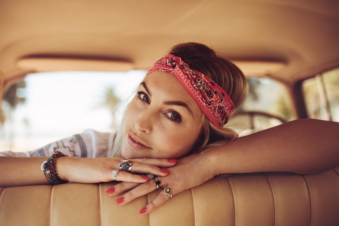 Female wearing bandana relaxing in a vintage car