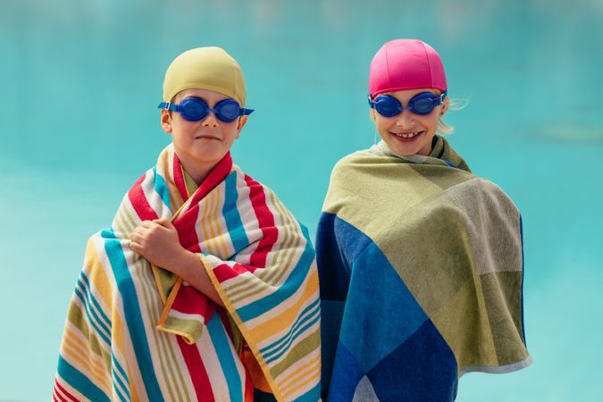 Two children smiling with towels wrapped around them