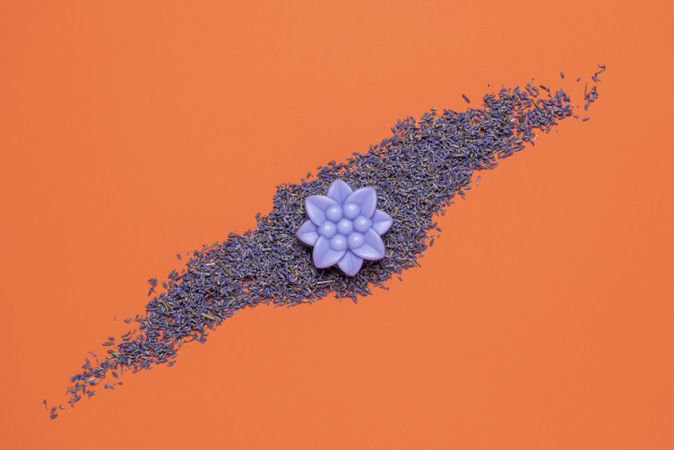 Lavender soap and seeds top view on orange background
