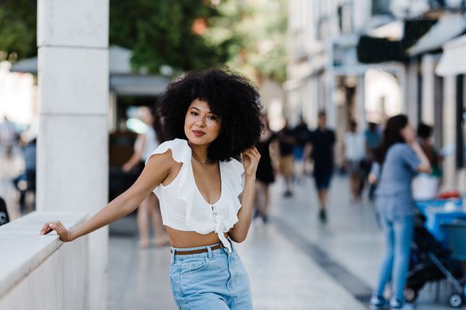 Black female leaning in concrete parapet