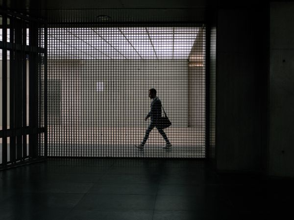 Silhouette of businessman holding suitcase walking in hallway