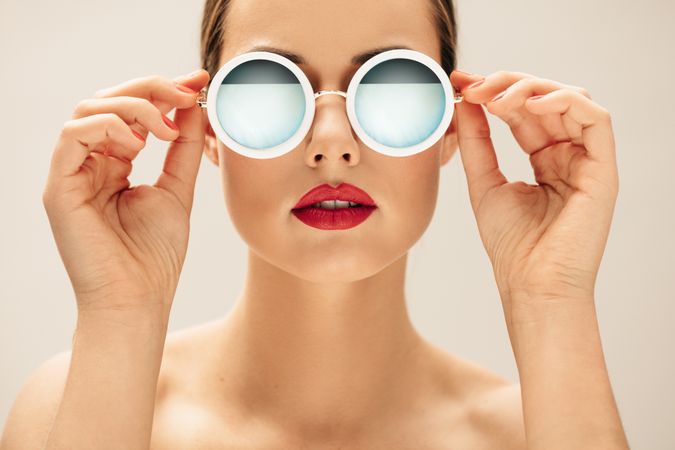 Close up shot of young woman in sunglasses and red lips