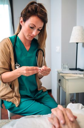 Doctor taking temperature to woman