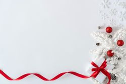 Gift box wrapped with red ribbons, and decorations, on light background