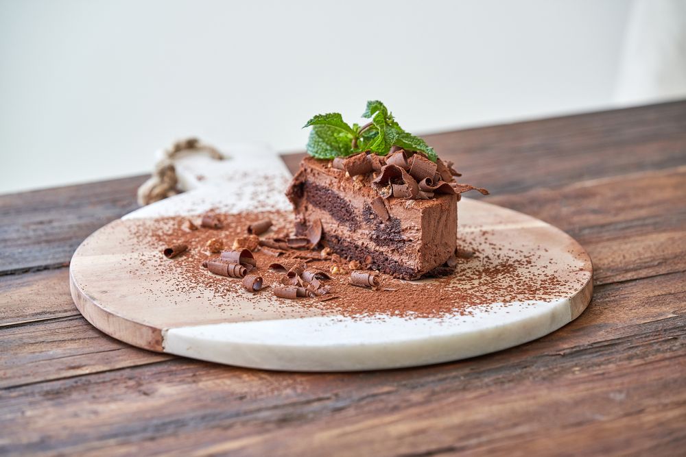 Delicious chocolate pastry on wooden board
