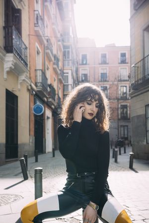 Young woman talking by phone in the street