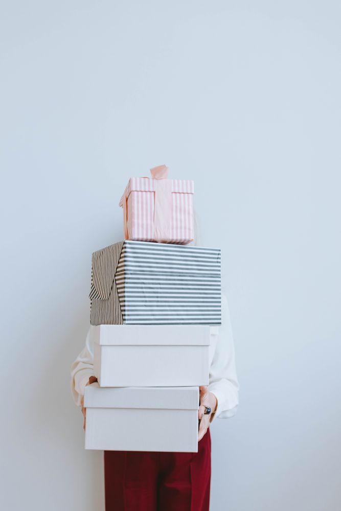 Person holding a stack of gift boxes