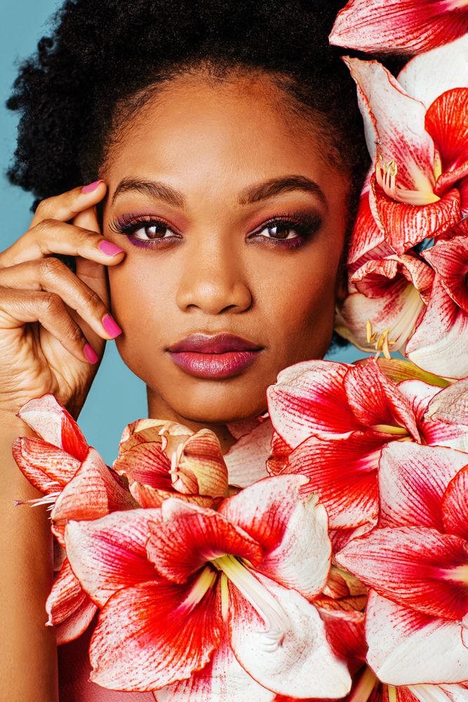 Studio shoot of Black woman surrounded by flowers