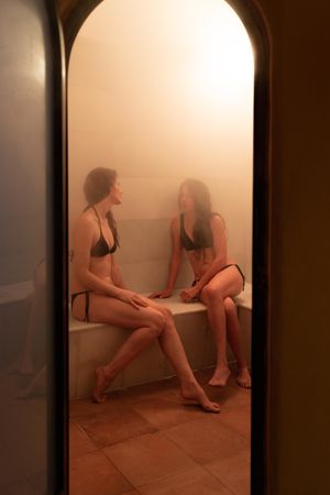 Female friends talking in steam room
