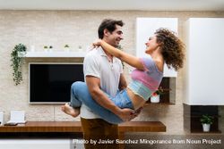 Smiling couple embracing in modern living room near TV 4mWMmB