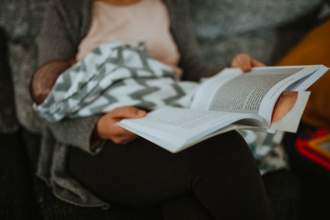 Women reads a book while breast feeding
