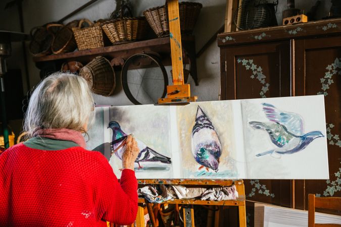 Anonymous woman painting on canvas in garden