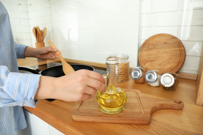Young woman cooking something in kitchen with modern interior