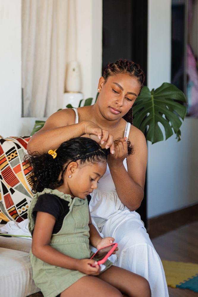 Mom combs her daughter's hair