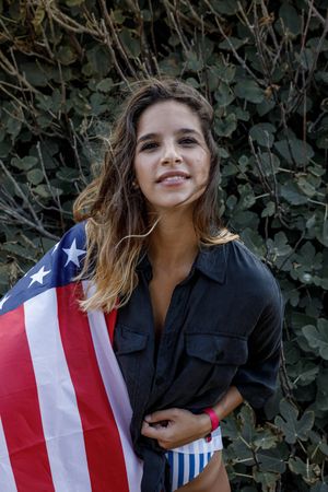 Young woman in casual clothing and American ensign enjoying in nature