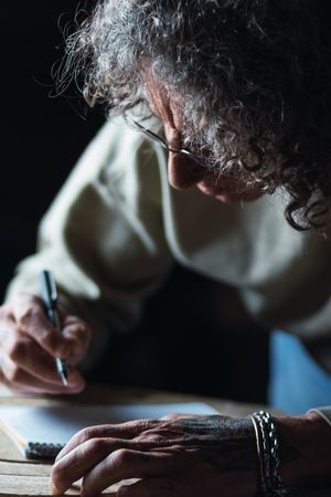 Male carpenter creating sketch in notebook in workshop