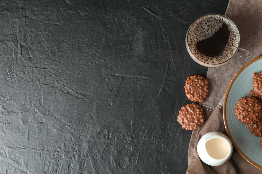 Chocolate cookies, cup of coffee and milk on table, space for text