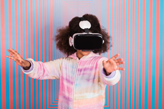 Black girl using VR goggles in studio