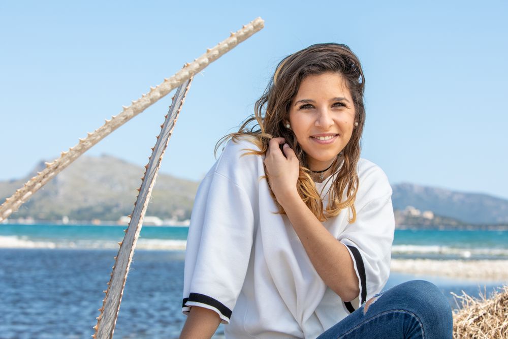 Young woman sitting near dried plants
