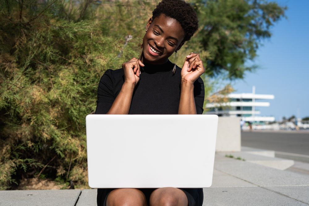 Serious female surfing laptop near modern building
