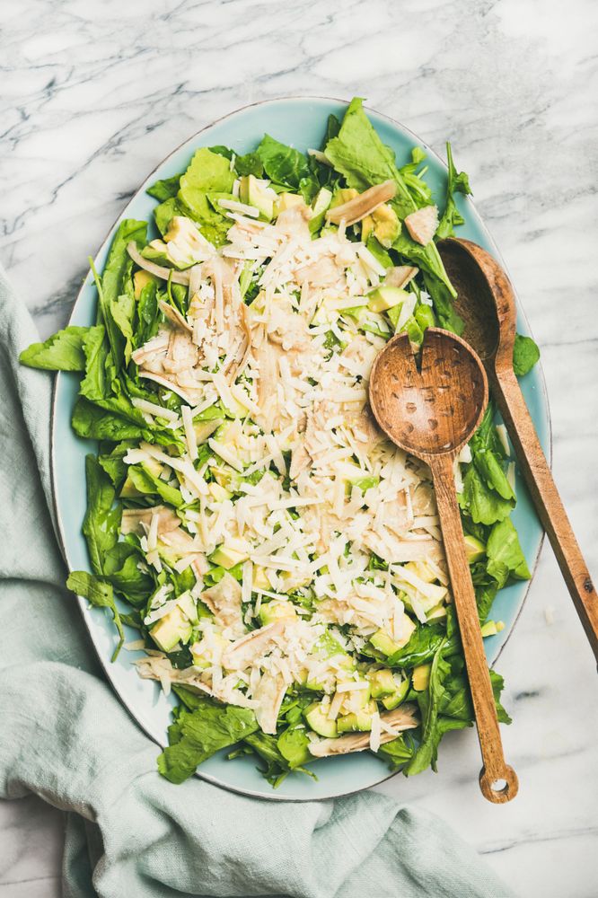 Artichoke salad with wooden serving spoons on marble background