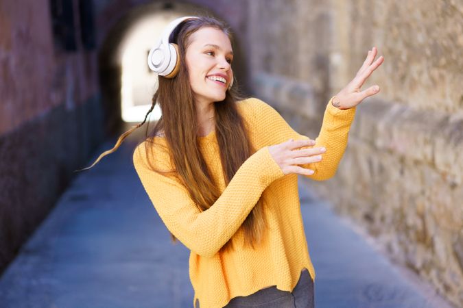 A Joyful Young Woman Delightfully Enjoying Music While Relaxing in an Urban Setting Today