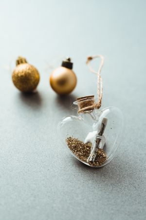 Glass heart with note inside and Christmas baubles