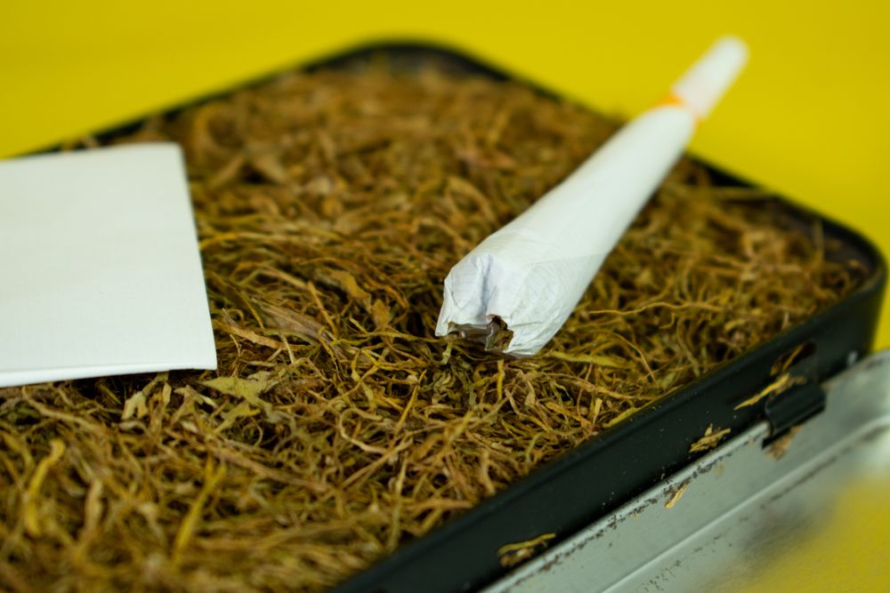 Hand rolled cigarette on loose tobacco