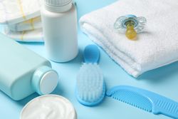 Baby hygiene accessories on blue background, close up