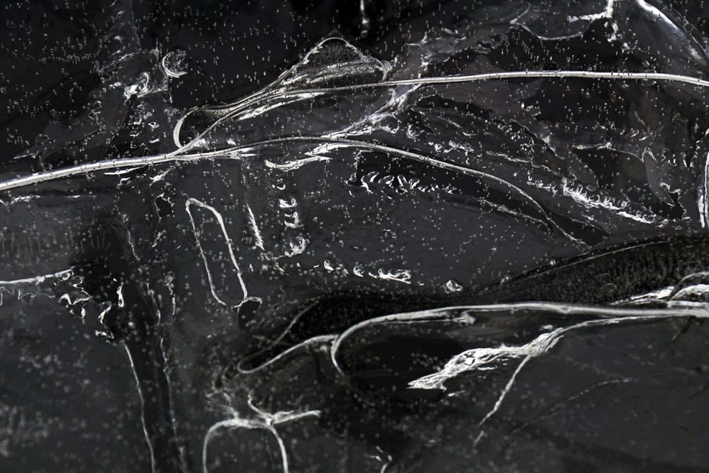 Fragment of thin ice on dark frozen river