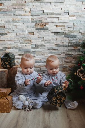 Babies examining Christmas presents at home