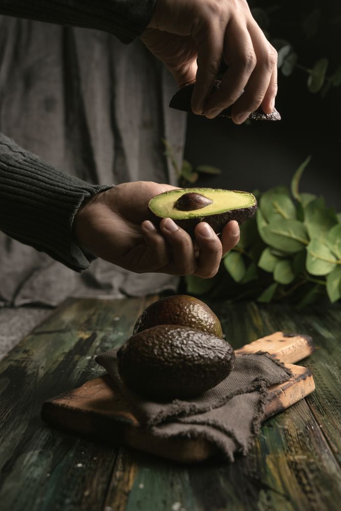 Person hands holding avocados