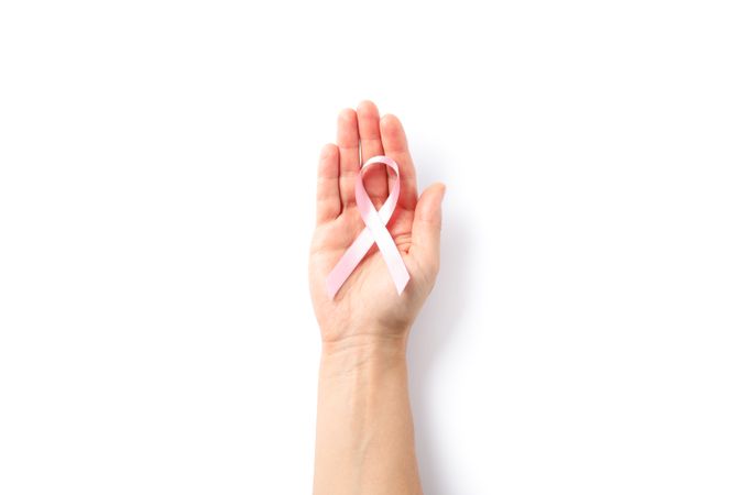 Female hand hold pink awareness ribbon, isolated on blank background