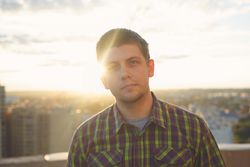 Portrait of male with sun setting in background