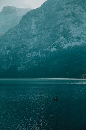 Lonely empty pier in turquoise water along mountain