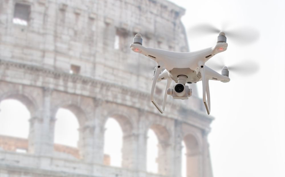 Unmanned Aircraft System Quadcopter Drone UAV In The Air Near The Colosseum In Rome.