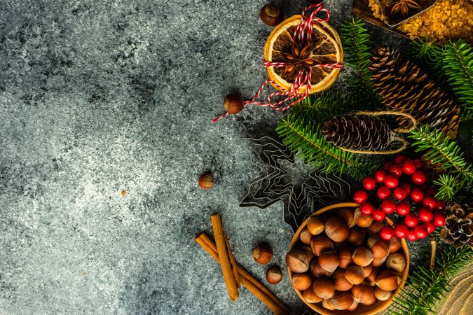 Christmas baking ingredients and branches on concrete counter with copy space