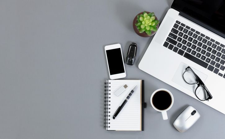 Flat lay view of gray desk with functional wireless technology and dark coffee