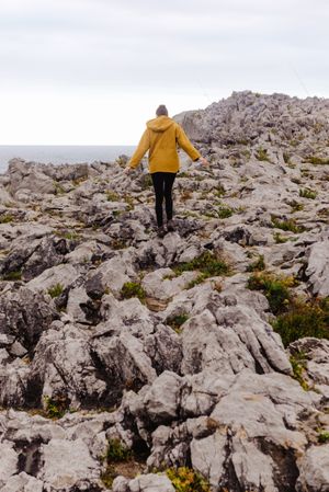 Traveler in solitude walking on rocky shore