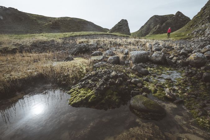 Woman walking along mountain river estuary