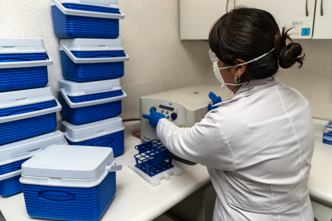 Researcher analyzing a sample acquired from a participant in an acute febrile illness