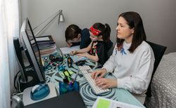 Woman teleworking with her children doing homework