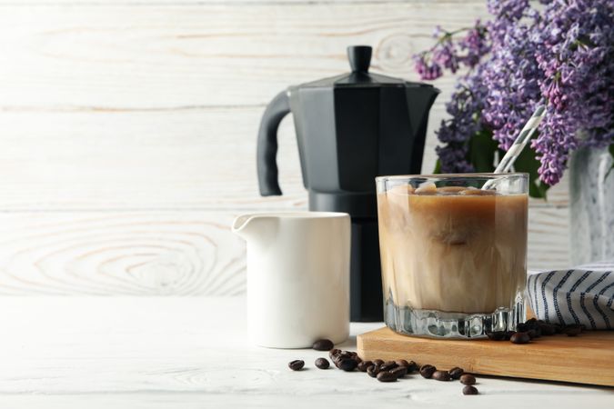 Composition with ice coffee and flowers on wooden background