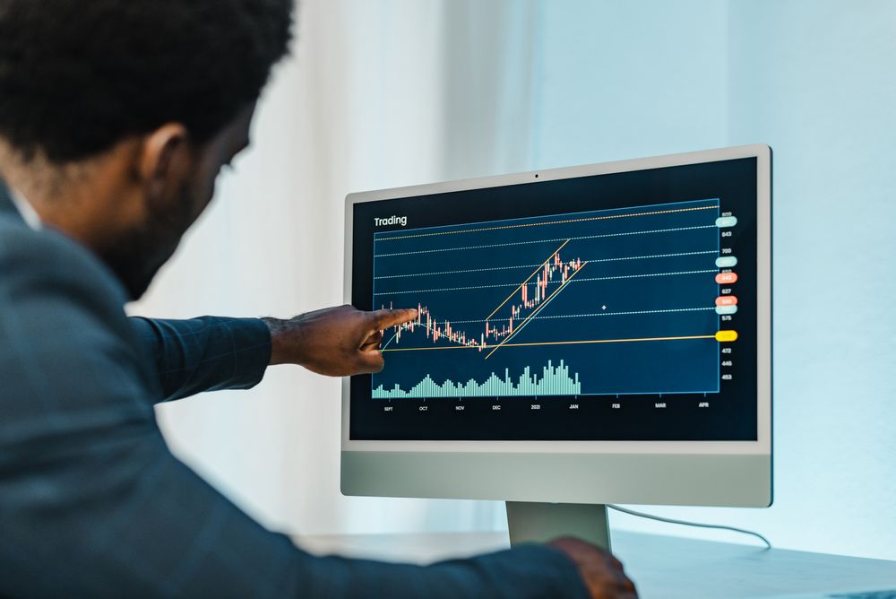 Black man analyzing financial diagrams on binary option