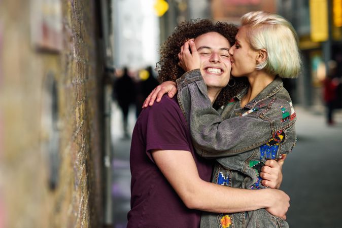 Female kissing and hugging her boyfriend on British city street