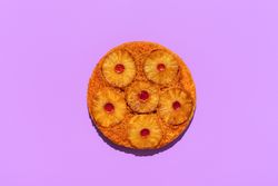 Pineapple cake top view, isolated on a purple background